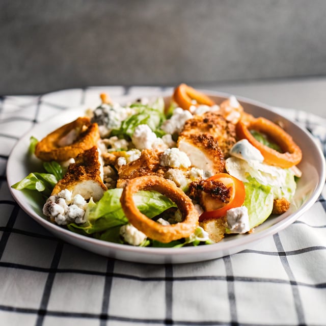 Buffalo Chicken and Crunchy Baked Onion Ring Salad with Blue Cheese.